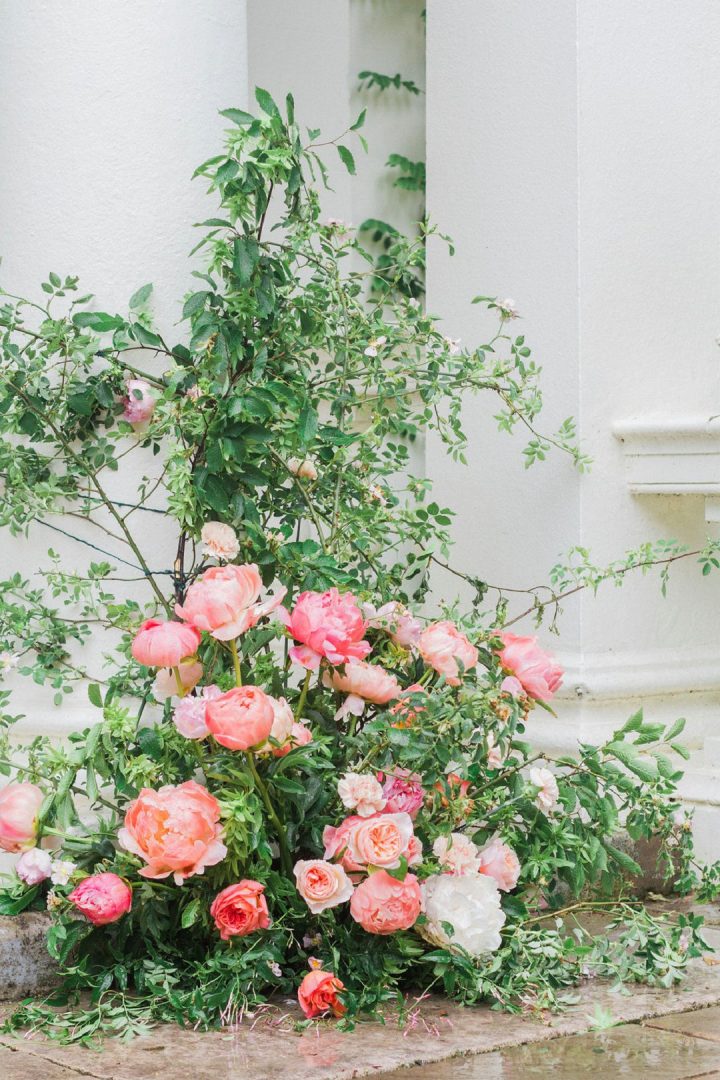 outdoor wedding ceremony with garden style flowers on pillars 