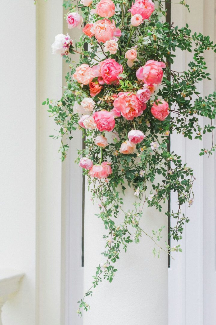 outdoor wedding ceremony with garden style flowers on pillars 