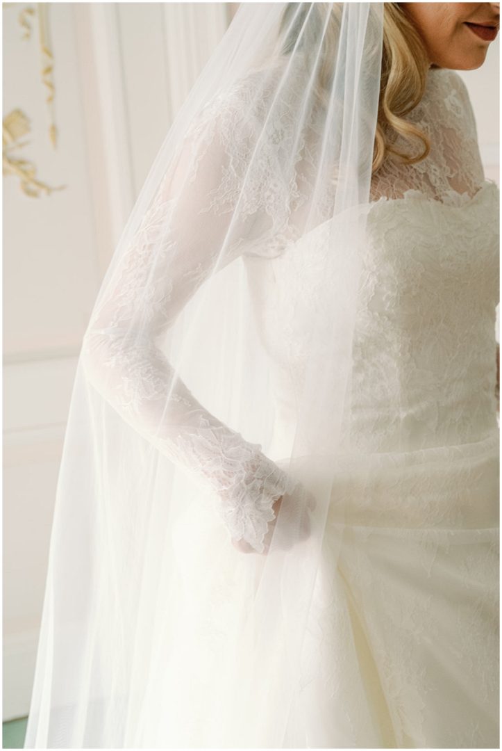bride in lace wedding dress holding dress Chiswick House Wedding