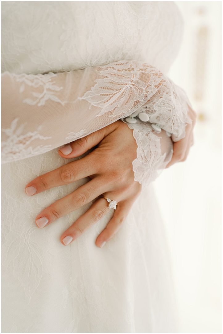 bride crossing lace sleeved arms Chiswick House Wedding