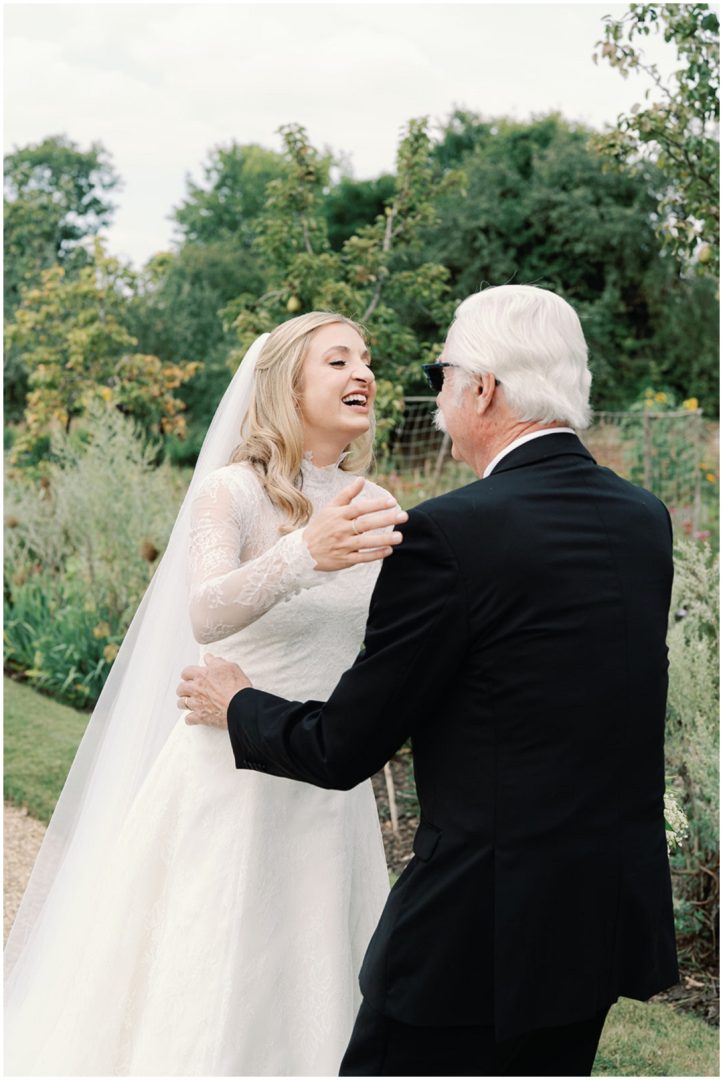 bride in lace wedding dress greeting father for first look at Chiswick House Wedding