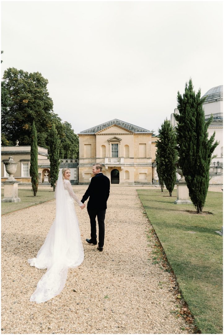 bride and groom holding hands walking through the gardens at Chiswick House Wedding