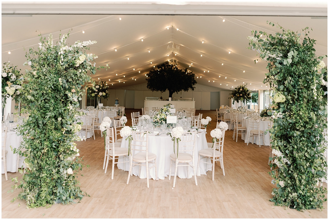 wedding reception at the pavilion with large green foliage deconstructed arch at Chiswick House Wedding