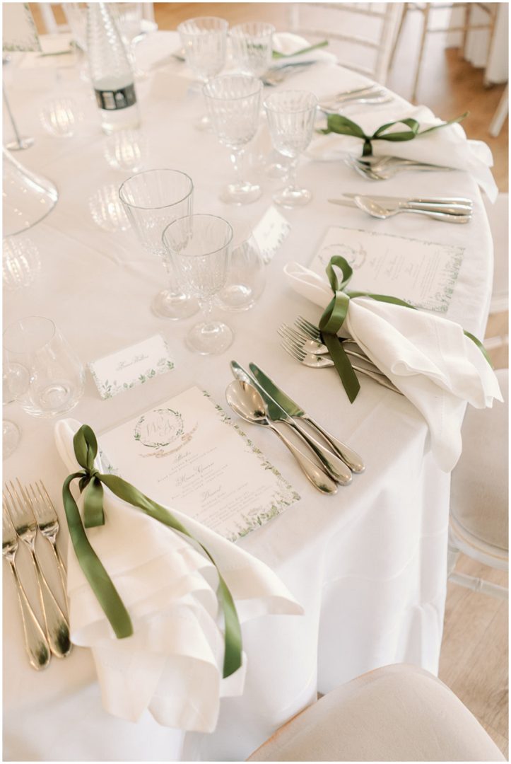 olive green ribbons tied adorn napkins with elegant printed menus at Chiswick House Wedding