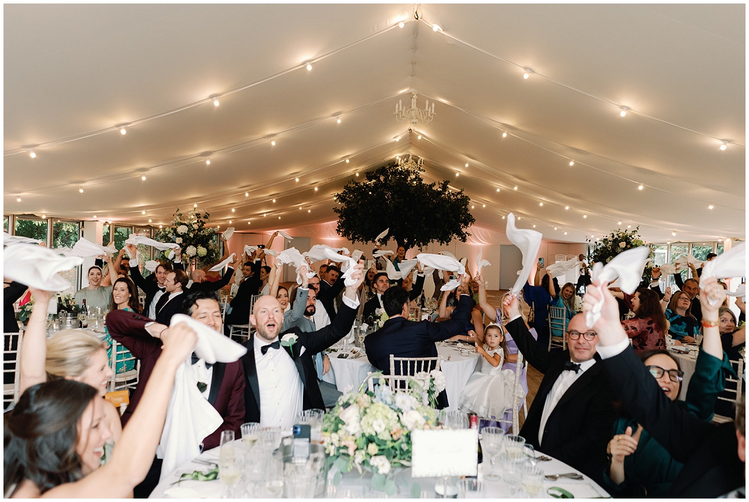 guests cheer couple entrance at Chiswick House Wedding