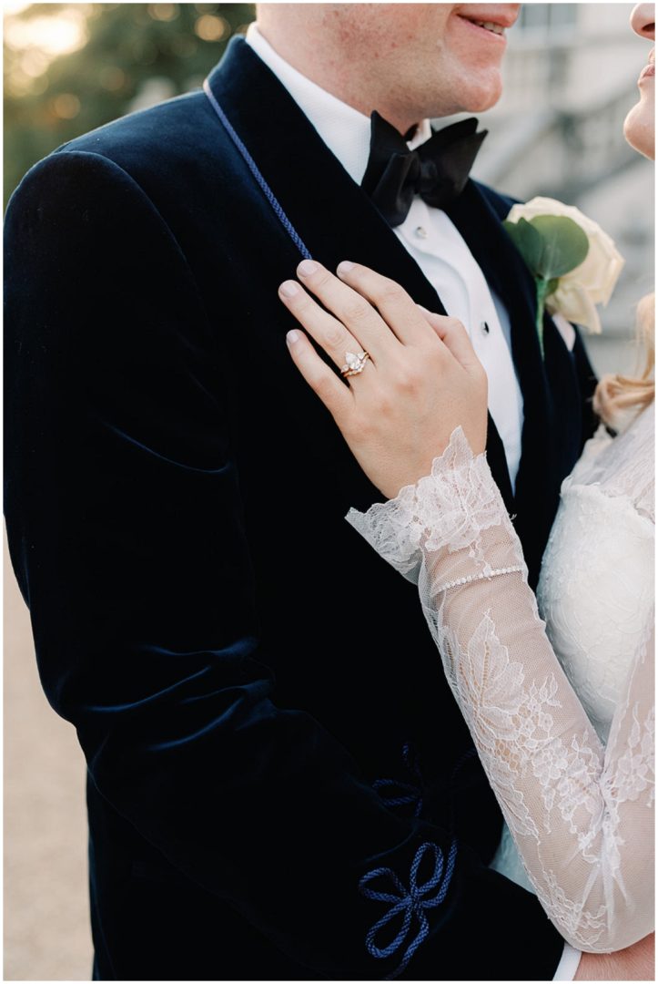 brides hand with wedding rings on grooms jacket at Chiswick House Wedding