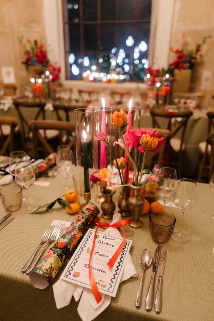 colorful candles in glass chimneys with illustrated menu and ribbon on napkin at Old Sessions House wedding