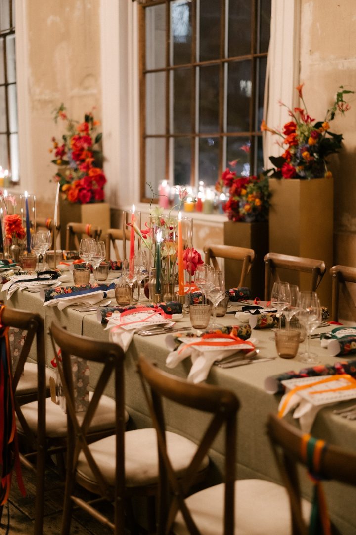 long dining tables with colourful flowers and candles at winter wedding at Old Sessions House London