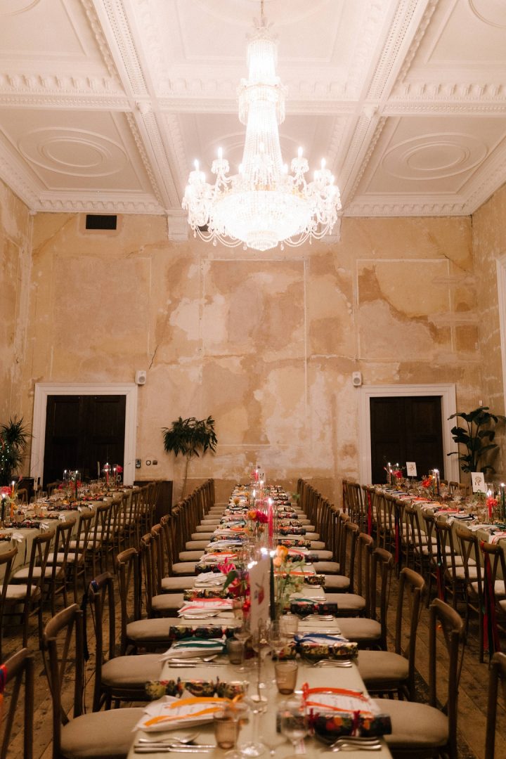 three long dining tables with colourful flowers and candles at winter wedding at Old Sessions House London
